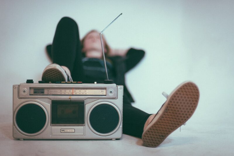 girl with her foot resting on an old boombox